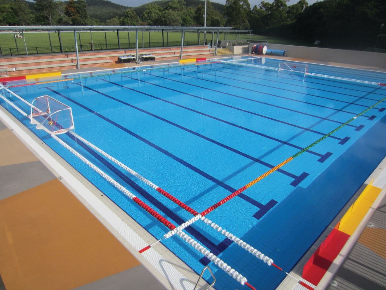 Outdoor 50-metre competition pool with lane ropes and a water polo goal